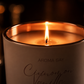 Aroma Bay candle with a lit flame on a dark background