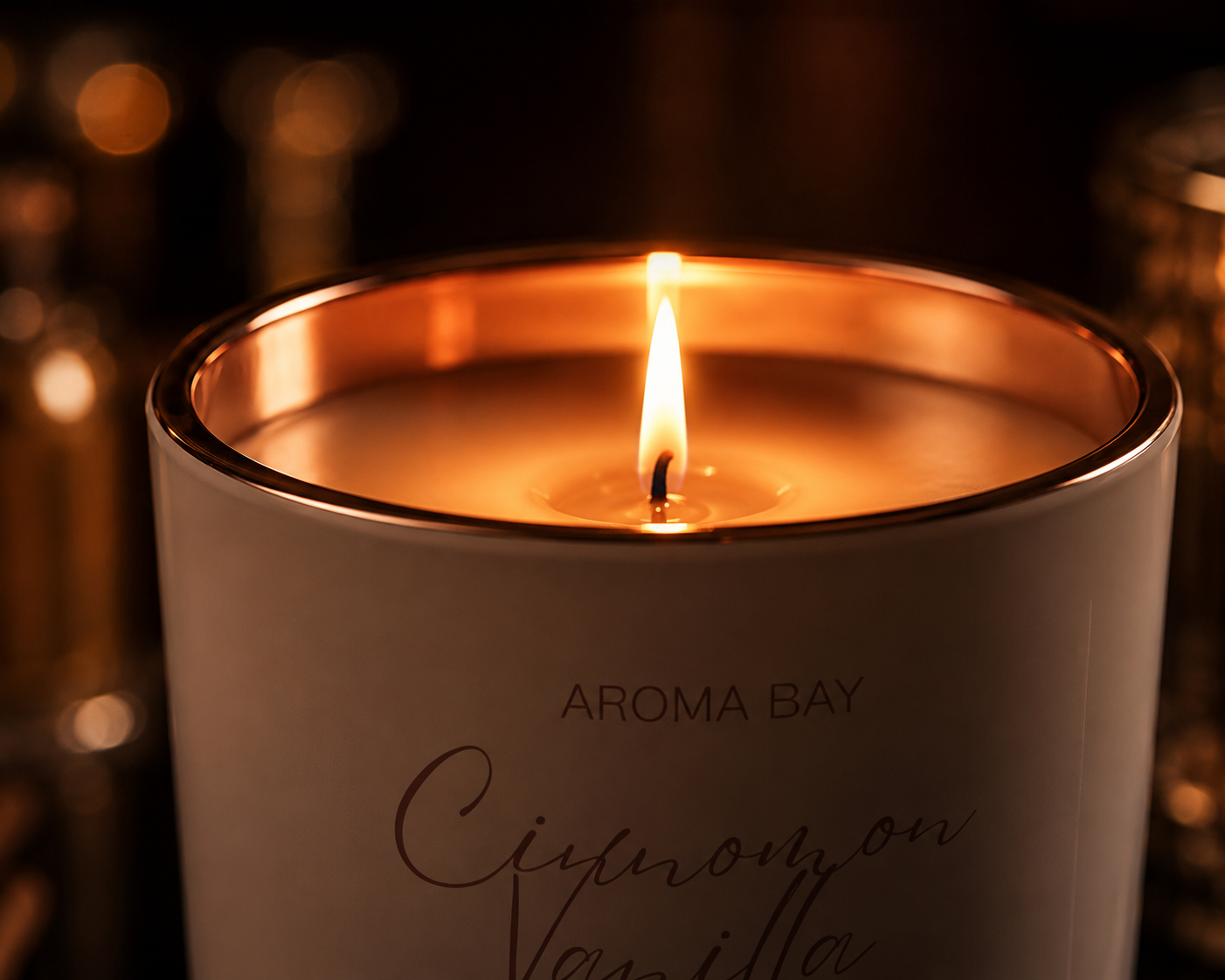 Aroma Bay candle with a lit flame on a dark background